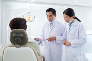 dentists-discussing-information-on-tablet-computer-RYF5M24