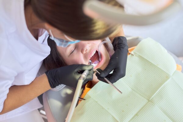 Close up dental treatment procedure in dental office. Dentistry, healthy teeth, medicine and healthcare concept